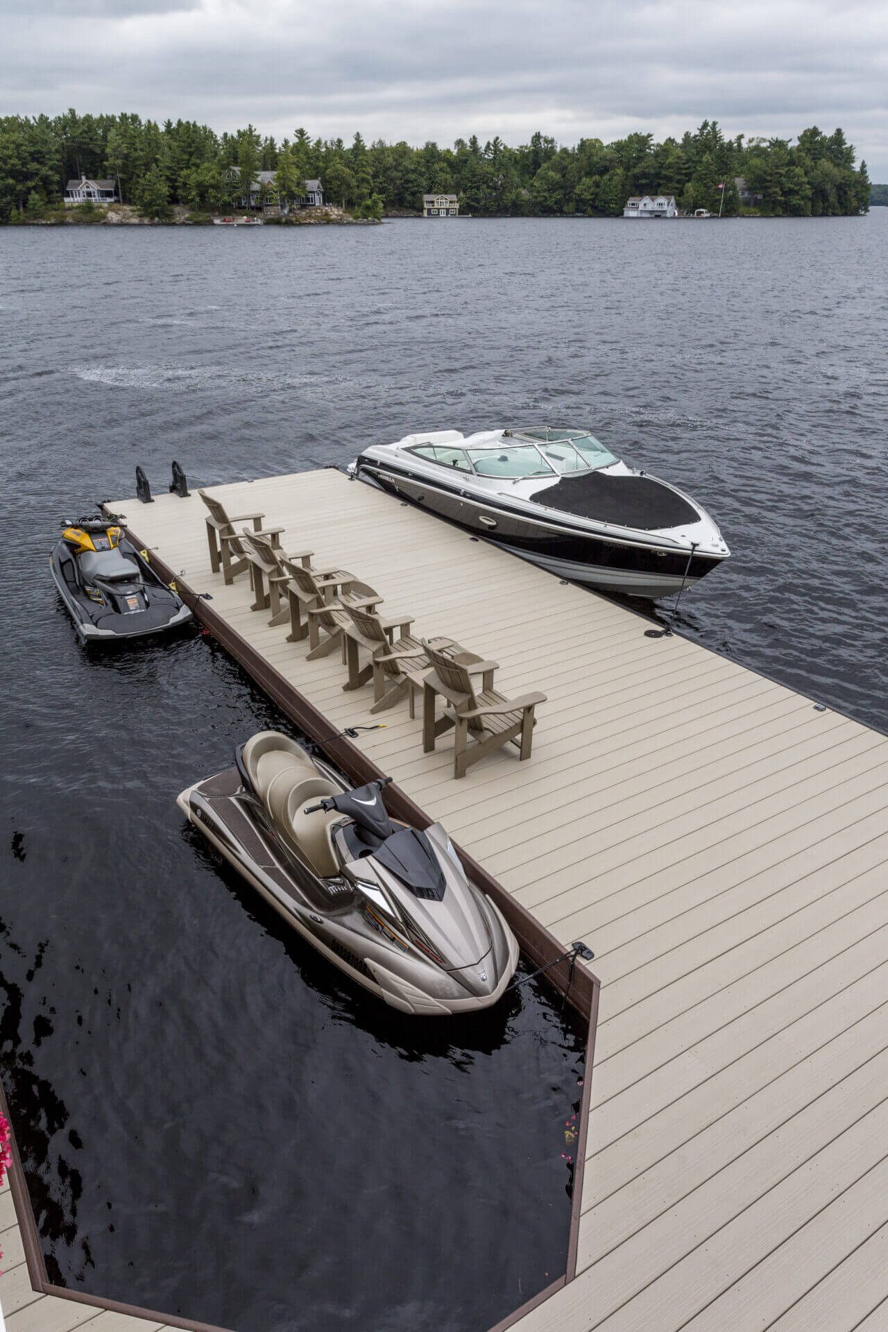 Composite decking dock with a boat and watercraft on a lake