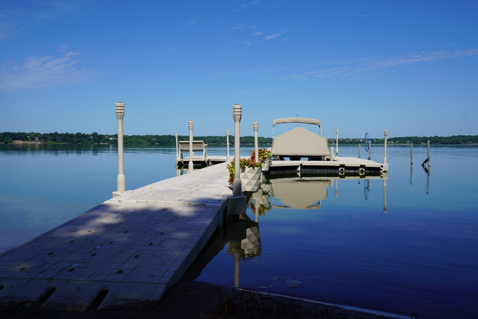 Paver floating dock with lighted posts and a moored pontoon