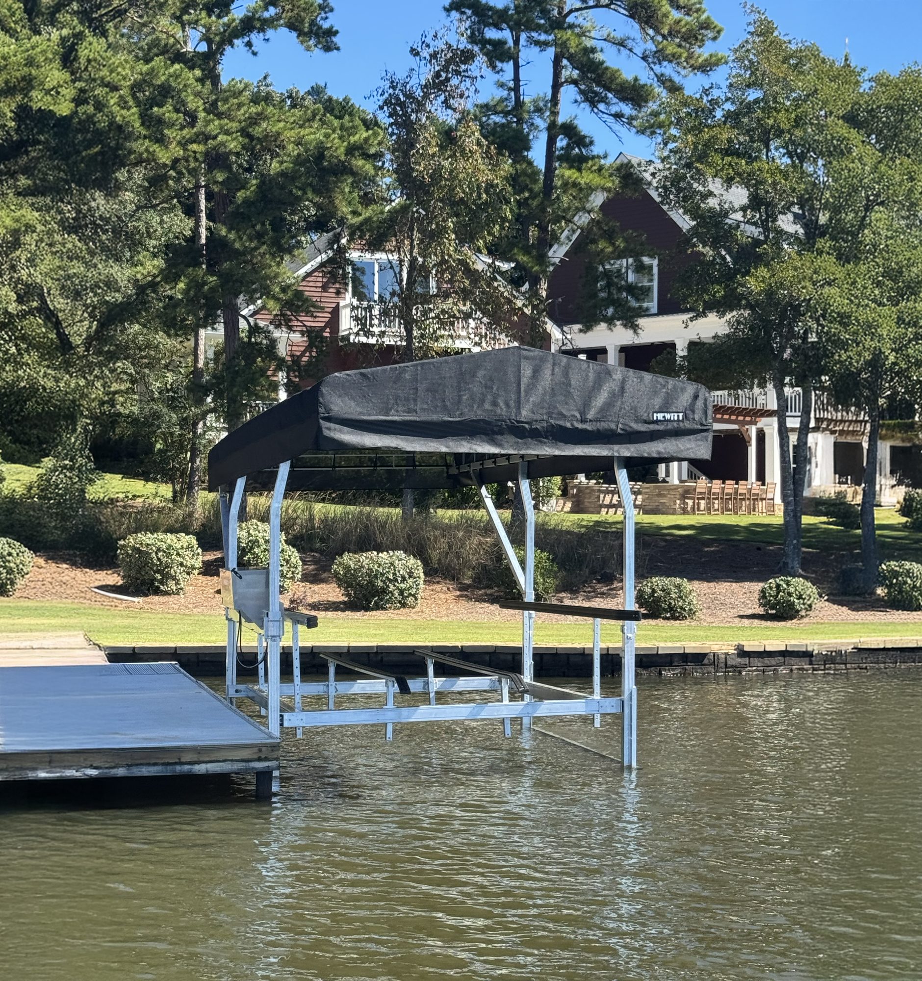 Hewitt canopy boat lift installed beside a lakeside dock