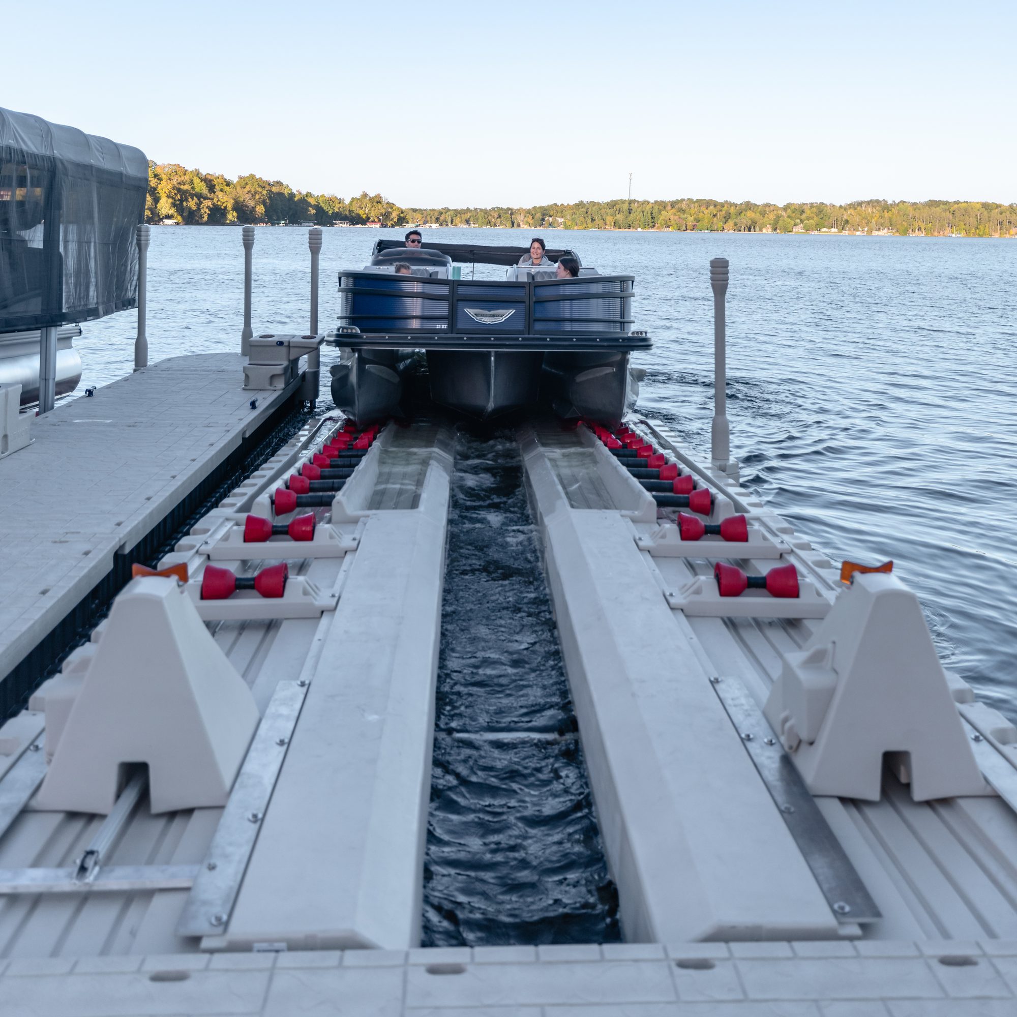 Family driving a pontoon onto a drive-on lift port