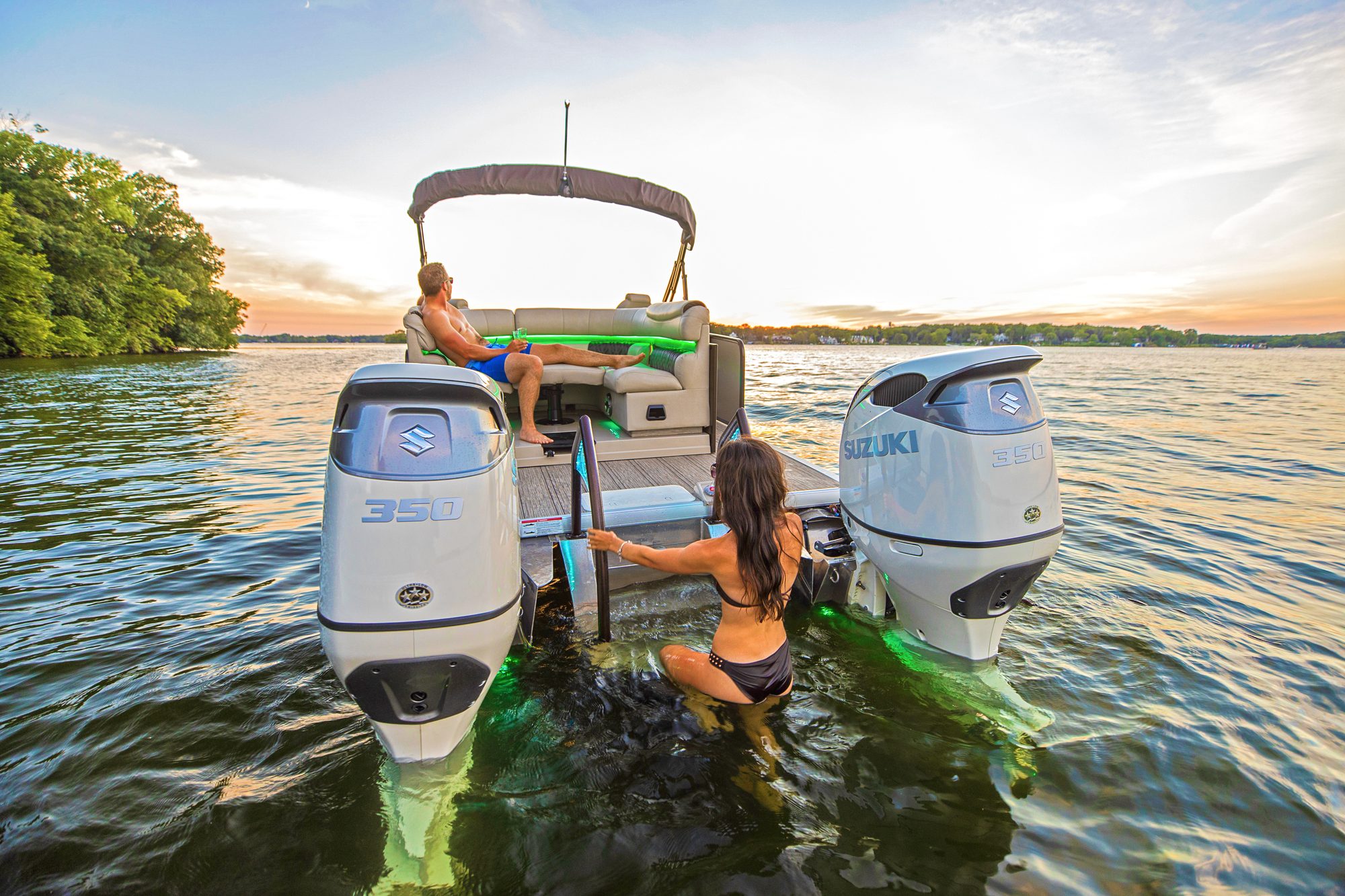 Twin Suzuki DF350A outboards on a pontoon at sunset